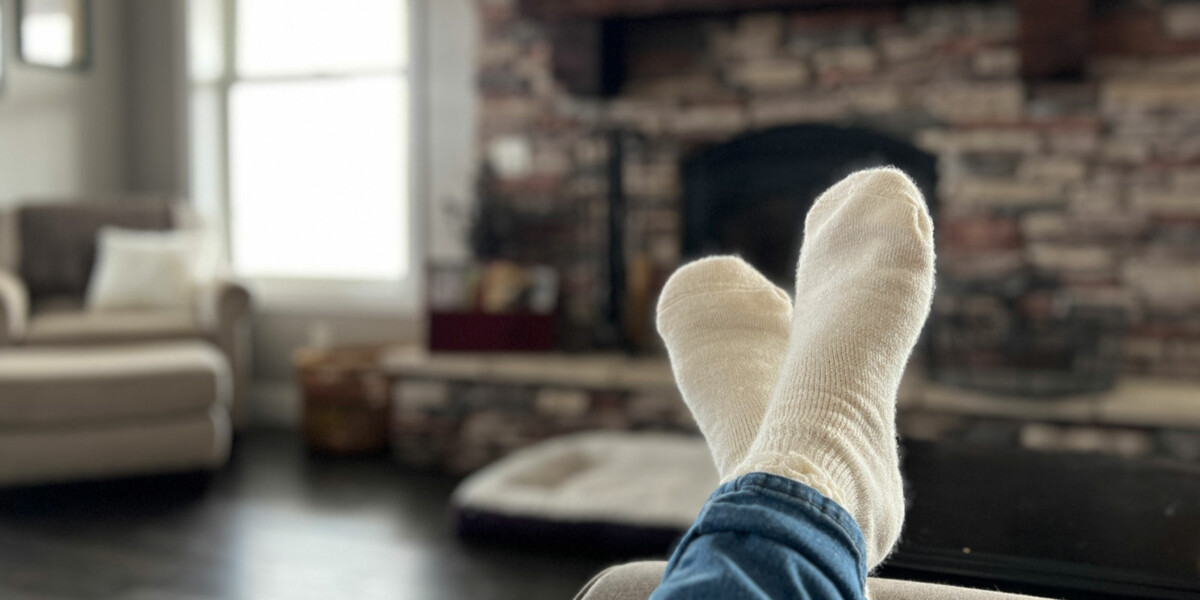 Woman Wearing Alpaca Socks in Front of Fireplace